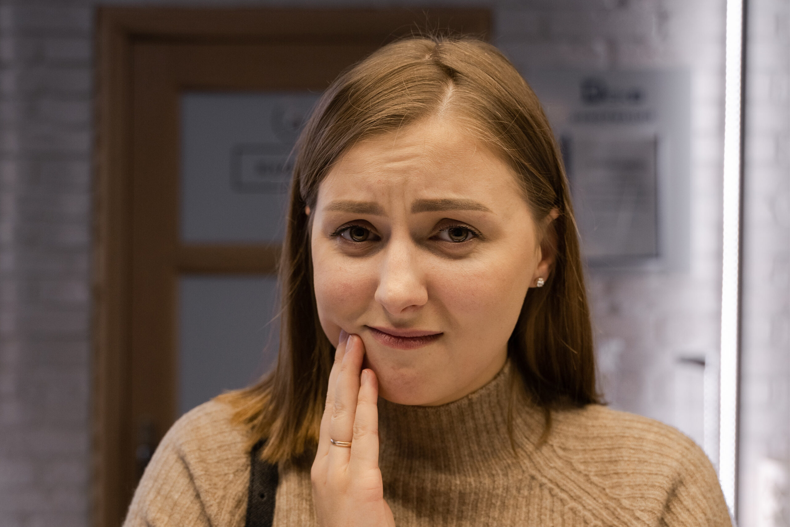 Woman holding mouth in pain