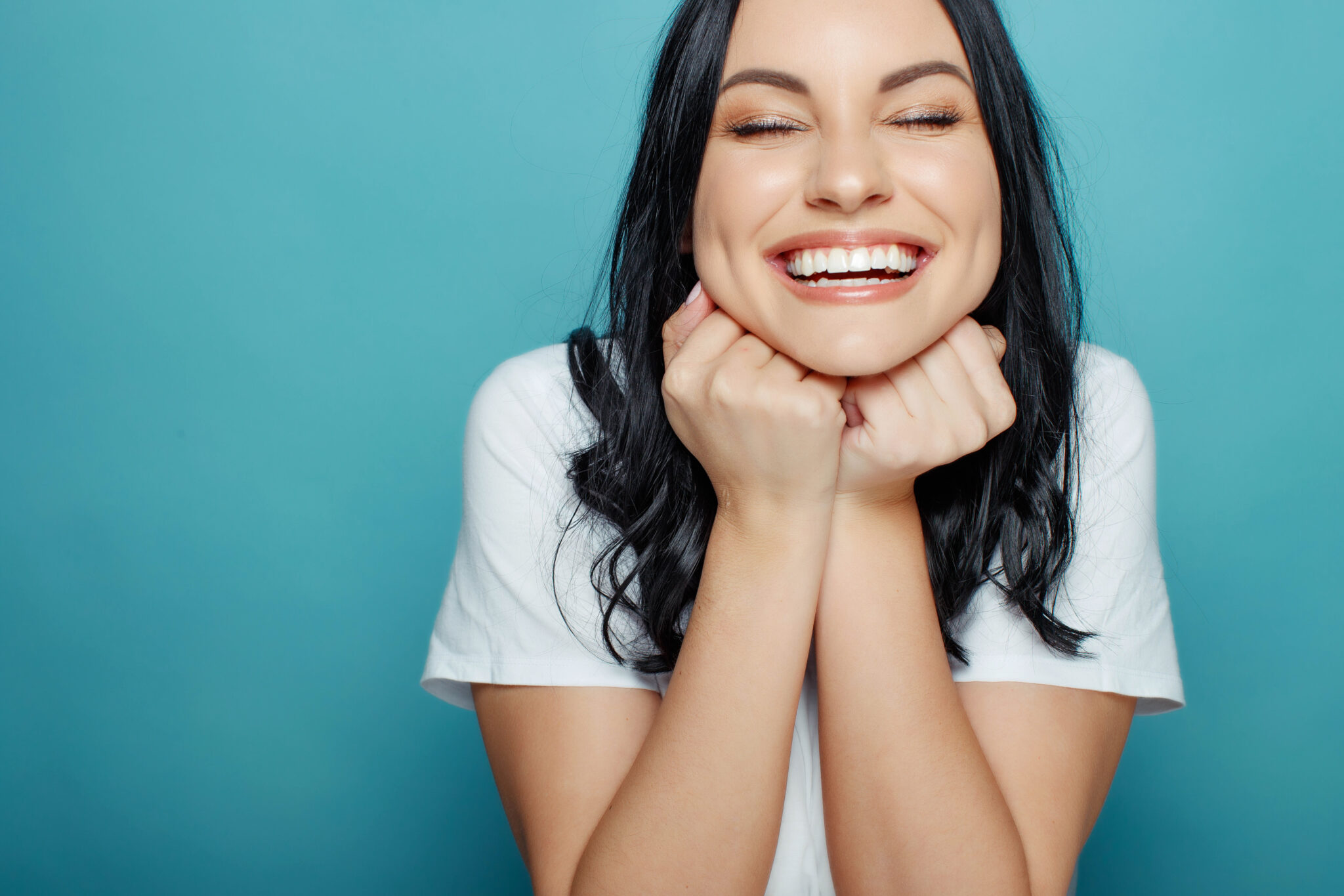 Woman smiling on teal background