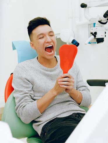 Man in dental chair with mirror