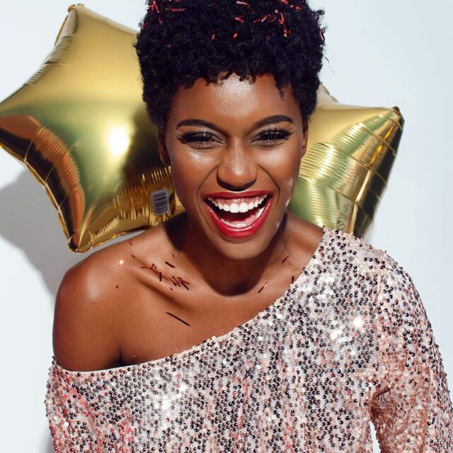 Woman smiling with gold star balloons